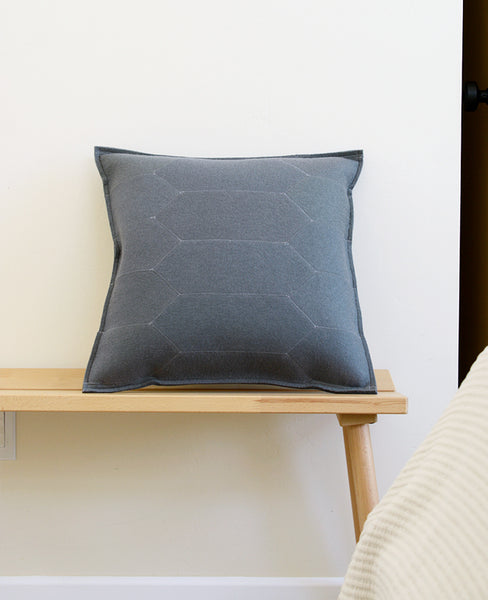 Grey wool felt throw pillow on a bench