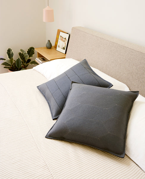 Grey wool felt throw pillows on a modern bed