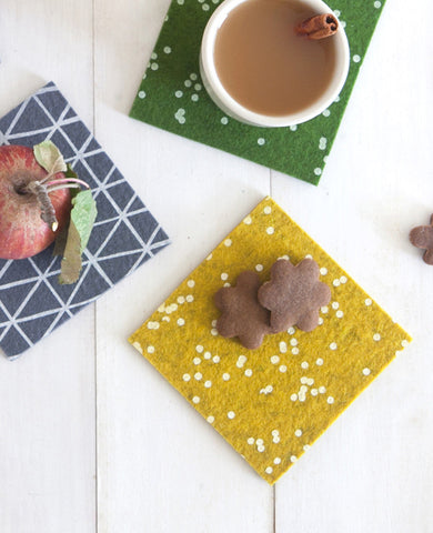 Colorful patterned felt coasters with fall snacks and apple cider