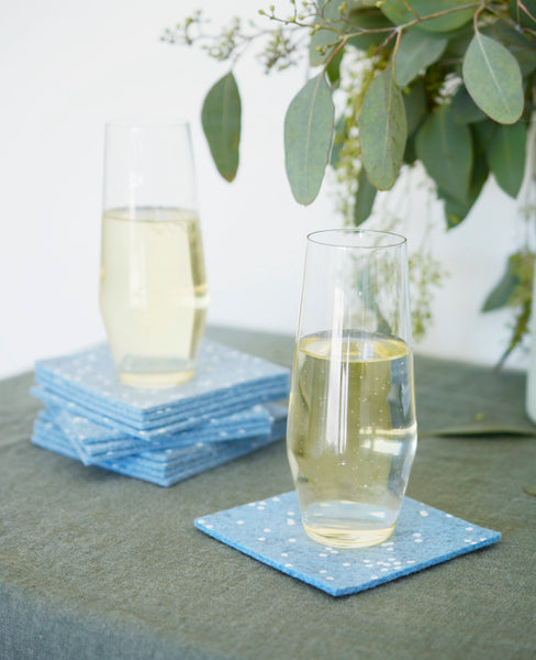 Blue felt coasters stacked with champagne glasses